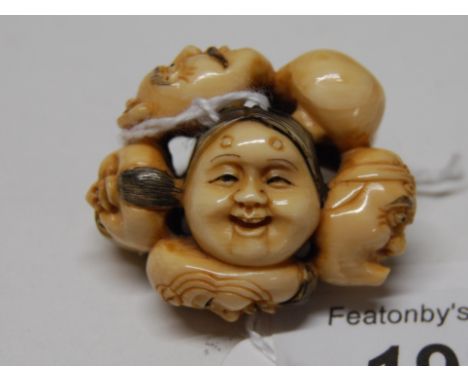 Early 20thC Japanese carved ivory netsuke, a study of 7 conjoined heads depicting the characters of the Noh play, inscribed c