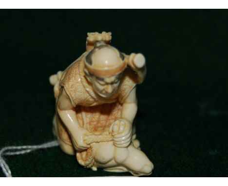 Early 20thC Japanese carved ivory netsuke, a study of a huntsman with a bow & arrow on his back kneeling, holding an upturned