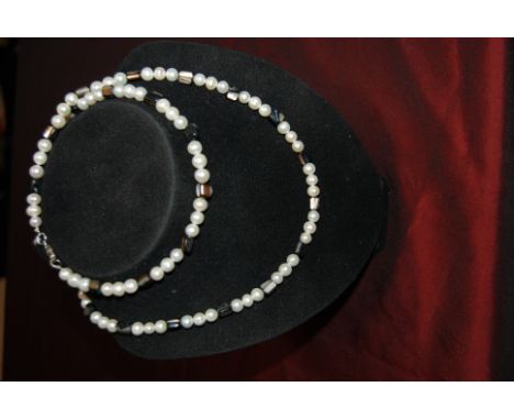 Long modern string of pearls divided by blocks of Mother of Pearl and shell with a silver clasp, 79cm long.