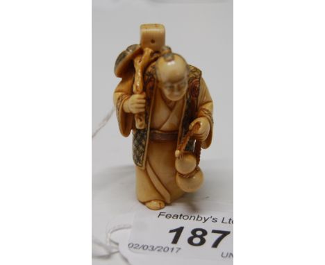 Early 20thC Japanese carved Ivory netsuke depicting a man holding a double gourd shape drinking vessel in one hand and in his