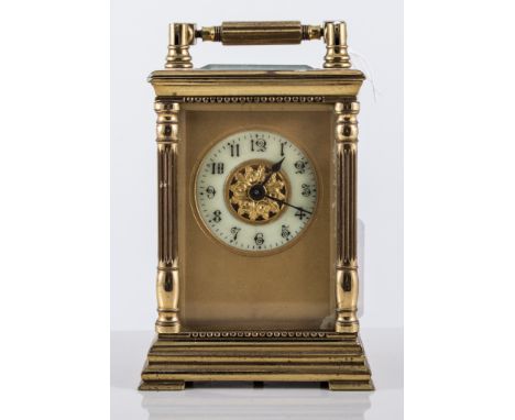 French brass-cased carriage clock, the top with a swing handle, visible escapement, the case with fluted columns, stepped bas