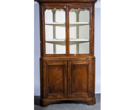 Welsh oak standing corner cupboard with glazed upper section, bracket feet, width 104cm, height 197cm.