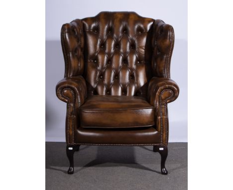 Modern leather wing-back easy chair with button upholstery.