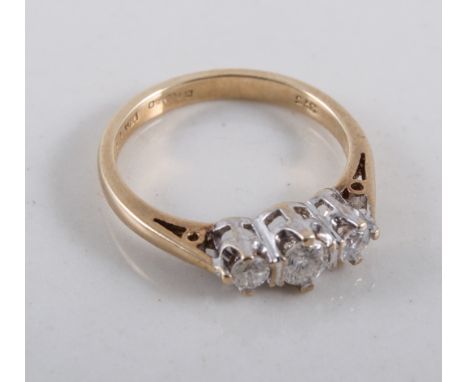 A diamond three stone ring, the brilliant cut stones claw set in a 9 carat yellow and white gold mount, ring size H.