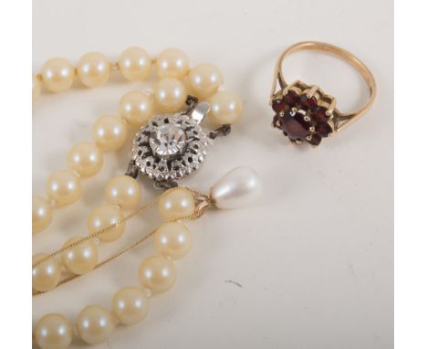 A garnet cluster dress ring, pearl drop pendant and chain and two row string of simulated pearls with diamante snap, the dres