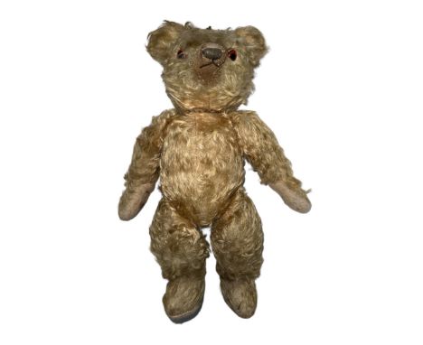 A post-war Chad Valley teddy bear with light curly fur orange and black eyes, jointed limbs and square The Chad Valley Ltd By