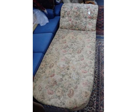 A VICTORIAN UPHOLSTERED DAY BED with buttoned head, on ebonised turned legs, and ceramic castors 200cm long, 75cm deep