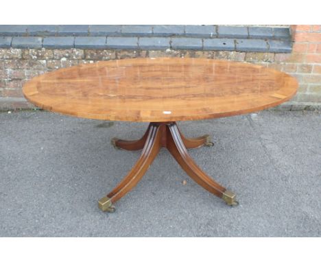A YEW WOOD VENEERED AND CROSSBANDED OVAL COFFEE TABLE on turned column and swept legs 121 x 83.5cm, a mahogany workbox, and I