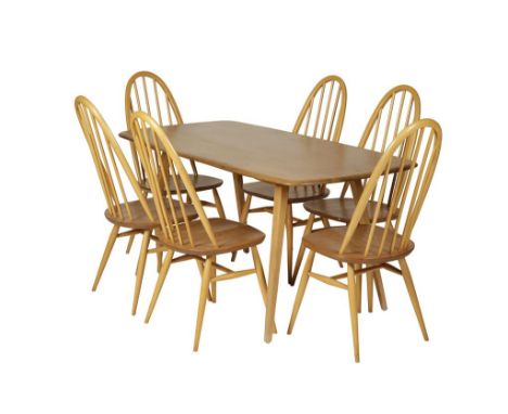 ERCOL: A LIGHT ELM DINING TABLE, the oval top on four tapered legs, with six spindle backed chairs, the table 151cm L x 75cm 