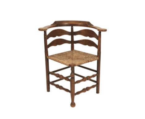 LATE GEORGE III ELM LADDER-BACK CORNER CHAIR with a "U"-shaped back over a rush seat and four bold baluster-turned front stre