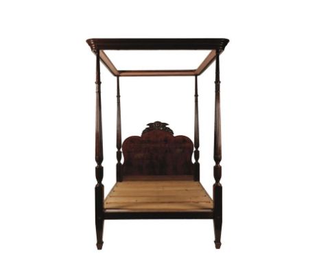 A MAHOGANY FOUR POSTER BED with moulded hanging rail above a shaped head board, with four turned leaf-carved and reeded balus