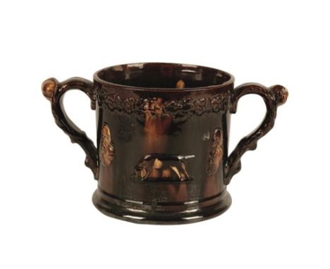 BROWN GLAZED POTTERY LOVING CUP moulded with portrait medallions of Admiral Lord Nelson alternating with Pointers, the interi