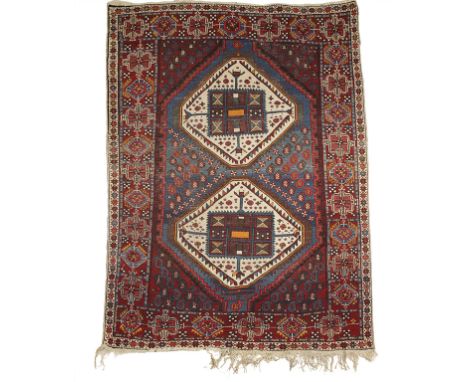 NORTH WEST PERSIAN TRIBAL RUG, the central blue rectangular panel worked with two ivory and polychrome hexagonal guhls within