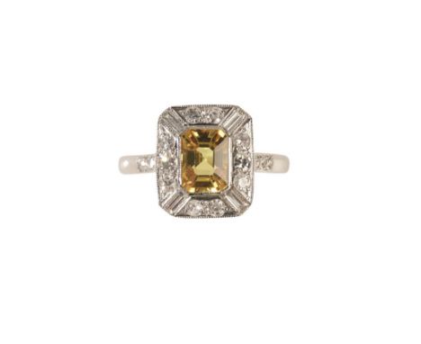 DIAMOND AND YELLOW SAPPHIRE RING the yellow sapphire collet-set, surrounded by a border of brilliant and baguette-cut diamond