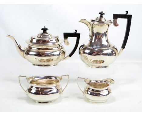 KIRWAN & CO LTD (probably); a George V hallmarked silver four piece tea set comprising a teapot of oval form with angled ebon