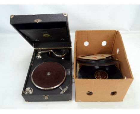 A Triumphon travelling record player, sold with a quantity of records. CONDITION REPORT: Turntable does spin when wound. 