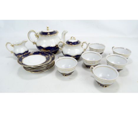 ZSOLNAY PECS; a cream ground blue and gilt decorated tea set comprising teapot, sucrier and cover, jug, six cups and six sauc