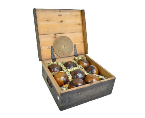 A set of eight lignum vitae bowling balls and a ceramic white glazed jack, in wooden box (9).