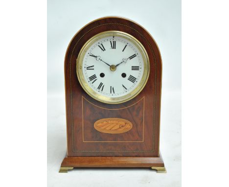 An Edwardian conch shell inlaid domed mantel clock, the circular set with Roman numerals, on brass bracket feet, with Jules R