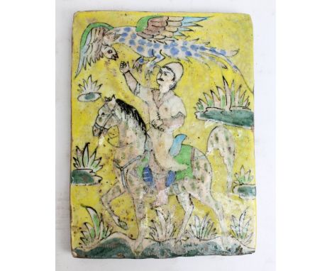 An 18th century Persian Isnik rectangular tile painted with a figure upon horseback with exotic bird above his head, 29.5 x 2