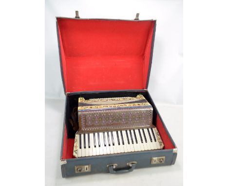 A Soprani mid-20th century piano accordion, the faux mother of pearl casing decorated with scrolling foliate design and marke