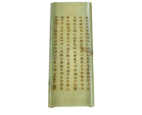 A Chinese green hardstone wrist rest modelled as a scroll with engraved verses of character marks and an oval seal mark, 18.5