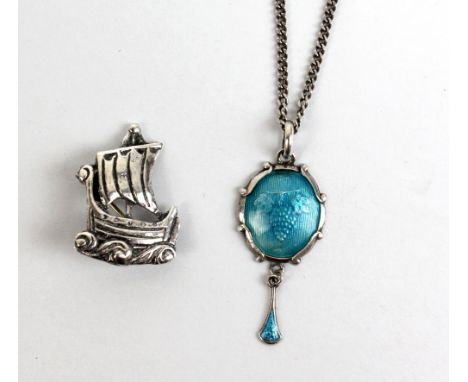A hallmarked silver brooch modelled as a longboat and a white metal pendant and drop with grape and vine motif and enamel det