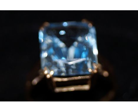 9ct gold dress ring with large central light blue stone. Possibly topaz. Size M