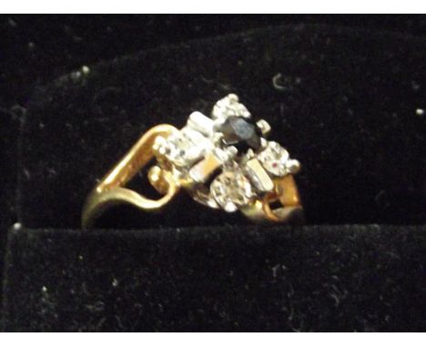 9ct gold cluster ring set with 4 diamonds and central sapphire. Size K