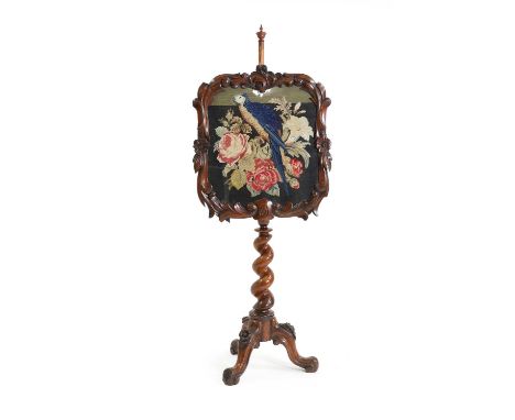 A Victorian carved walnut pole screen,  c.1870, with a tapestry decorated with a parrot nestled on a bunch of flowers, with b