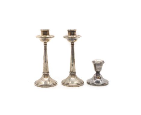 A group of three silver candlesticks comprising a pair by H J Cooper &amp; Co Ltd, Birmingham 1922, 17cm high, and a dwarf ca