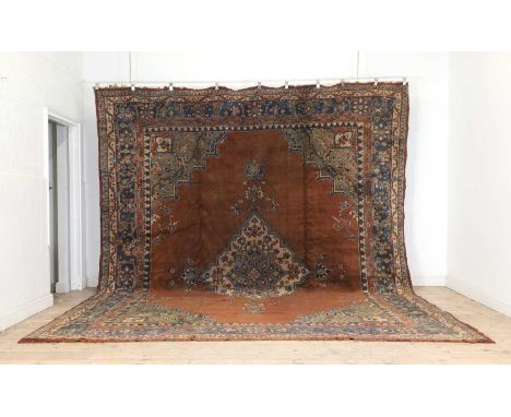 An Oushak wool carpet, early 20th century, the central field with a large diamond medallion to the centre on a burnt orange g