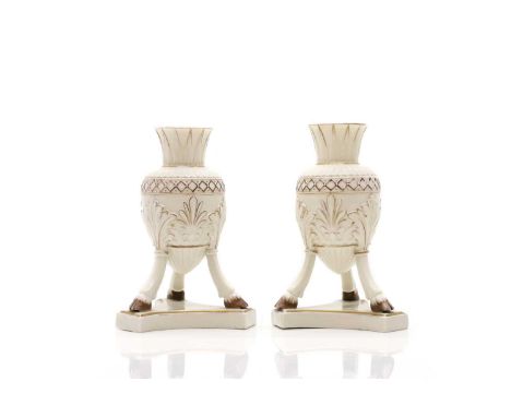 A pair of Belleek porcelain vases, first period, 1863-1890, the gilt highlighted amphora shaped bodies each on three cloven f