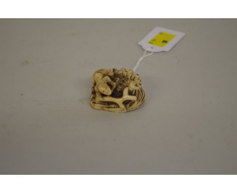 A Japanese carved antler netsuke,&nbsp;Edo period, depicting a figure on large shell or rock, 4cm wide.&nbsp; 