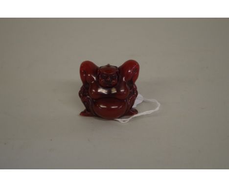 An amber style netsuke,&nbsp;of a Sumo wrestler, signed to base, 4.3cm high.&nbsp; 