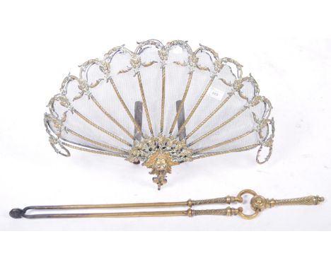 A 19th Century Victorian antique brass peacock fan shaped fireguard having a mesh fan with central lion mask panel and scroll