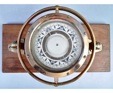 A rare early 20th Century brass ships gimbal compass raised on an oak plinth base. Large central compass with polished brass 