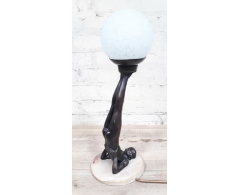 A contemporary Art Deco style lamp formed as a nude lady holding a glass globular shade with her feet on onyx base, height 43