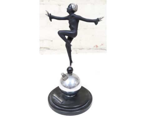 An Art Deco table lighter formed as a dancing girl with silvered hair, hands and shoes, atop a chrome ball with bakelite base