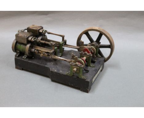 A stationary engine, raised on black metal base, and bearing plaque inscribed "W Foreman &amp; Sons", measuring 24 cm long 