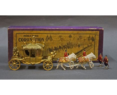 A Johillco miniature coronation coach, gold coloured with two Johillco figures, and displayed with a purple cardboard box