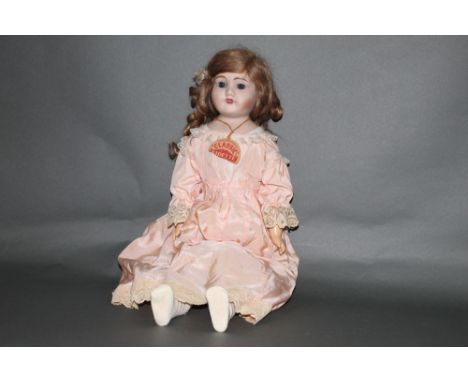 An early 20th century Mayer and Sheratt "Melba" bisque head doll, having fixed blue eyes, open mouth with four teeth, kid lea