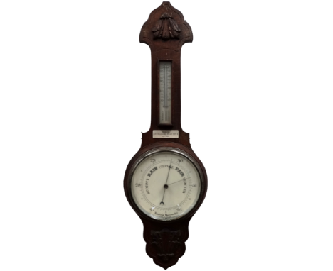 A mid 20th century carved oak aneroid barometer - incorporating a thermometer