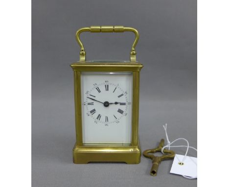 French brass and glass panelled carriage clock of small proportions, the enamel dial with Roman hour numerals and Arabic minu
