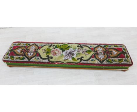 19th century tapestry upholstered long footstool on a mahogany base with four bun feet, 26 x 110cm 