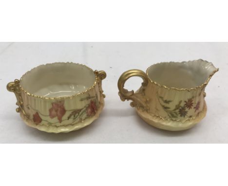 A Royal Worcester blush ivory sugar bowl and milk jug with floral designs and gilt handles