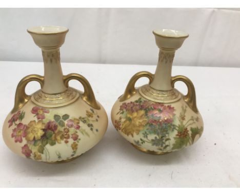 A pair of Royal Worcester vases with floral designs on blush ivory ground with twin gilt handles: H17cm