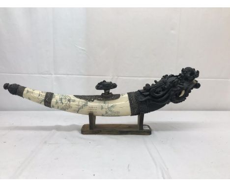 A large Chinese opium pipe on stand with dragon head and ivory-style carved body