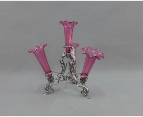 Art Nouveau style metal epergne with four cranberry glass trumpet shaped inserts, 31cm high 