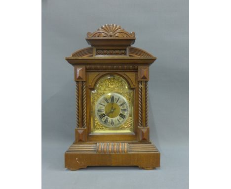 Oak cased mantle clock with a silvered chapter ring and Roman numerals with brass spandrels, 45cm high 